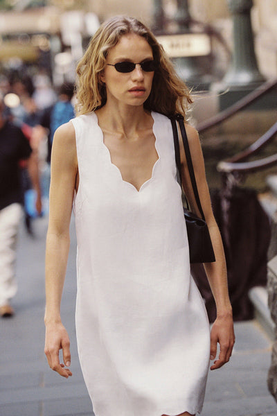 Zoe wearing LELA WHITE SLEEVELESS LINEN MINI DRESS